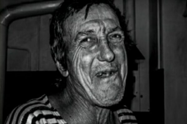 Chiede avanzi di cibo al cameriere di un ristorante.